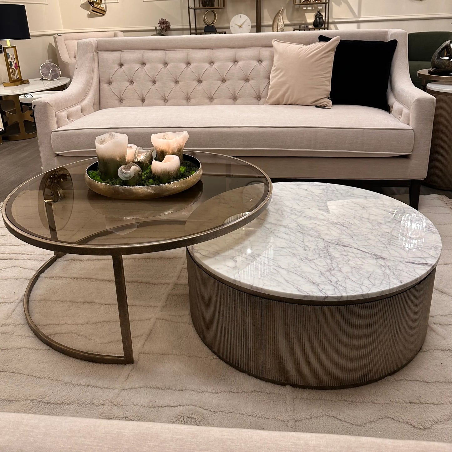 Set of two nesting coffee tables crafted from brushed bronze with smoked glass and white natural marble tops. Styled in a beautiful living room, available to purchase from Albury House Interiors, Matching Tye Essex.