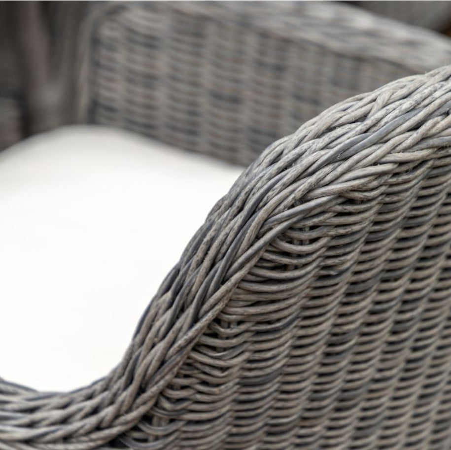 A 5-piece outdoor dining set featuring a round glass-top table and four high-back grey woven wicker chairs with white seat cushions, shown against a plain white background available at Albury House Interiors.