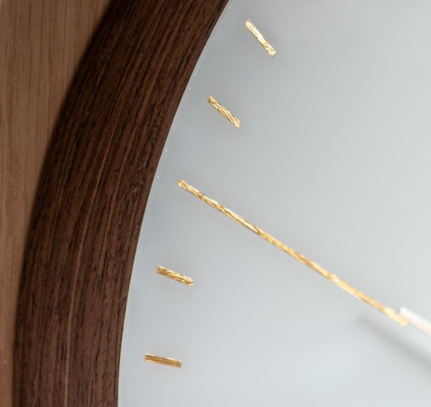 white clock face with gold numbers and hands with a dark wood surround.