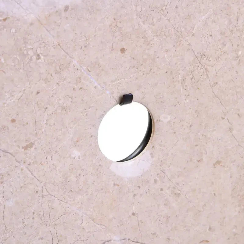 coco-cream-neutral-natural-marble-round-disc-sculpture-on-black-plinth-stand-at-albury-house-interiors-accessories-for-interior-designers