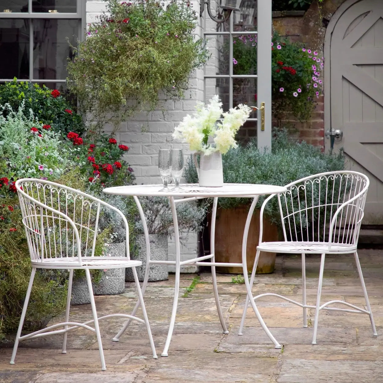 white metal outdoor table and chairs on a patio deck from Albury house interiors essex