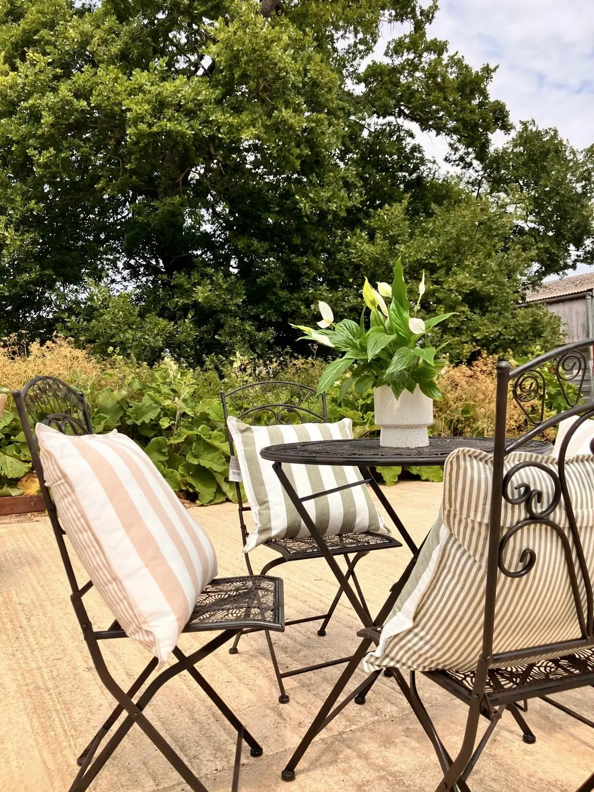 esher-thick-and-thin-stripe-reversible-sof-outdoor-cushions-in-natural-beige-and-white-and-green-and-white-on-bistro-set-at-albury-house-interiors