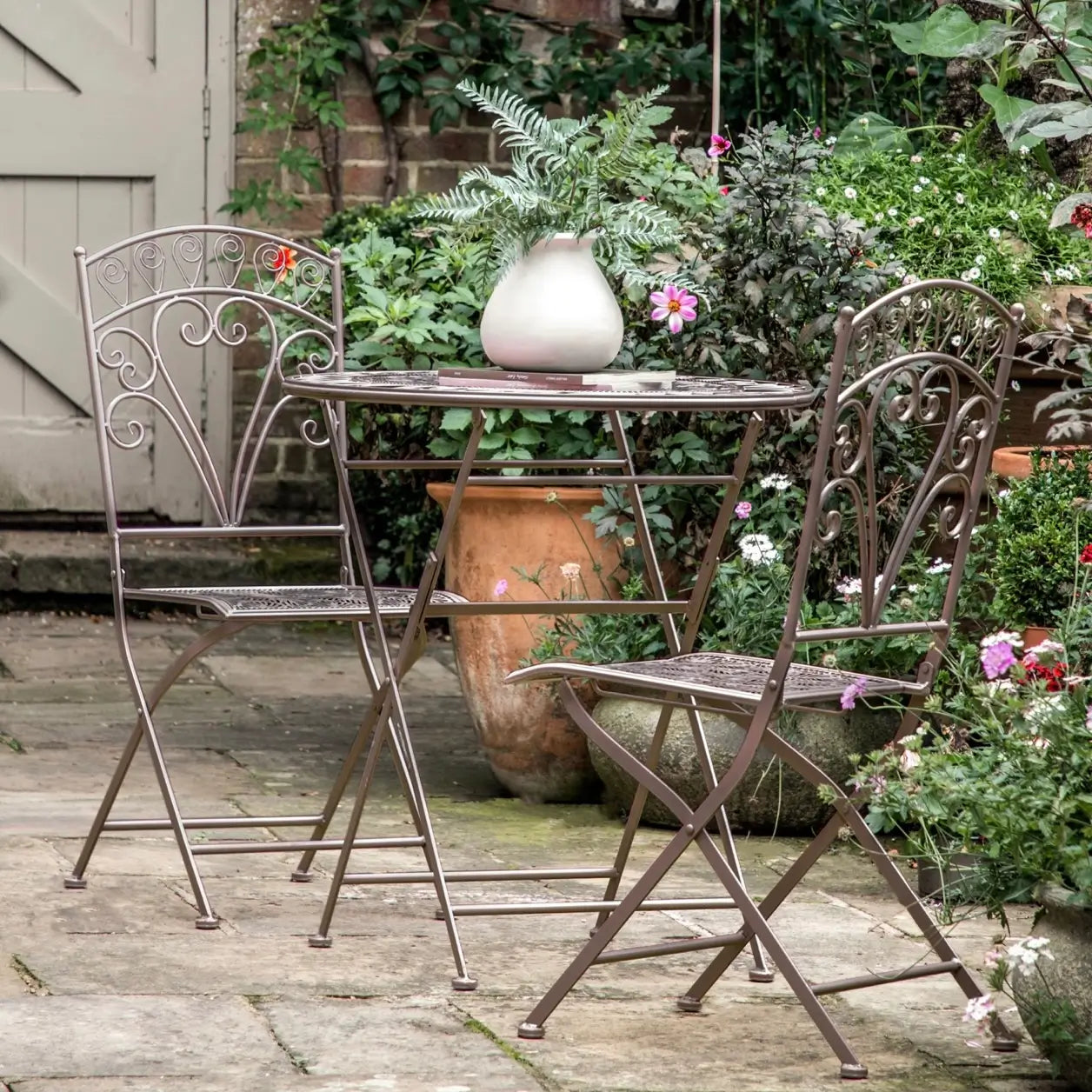 fleur outdoor metal table and chairs set on a garden patio at Albury house interiors