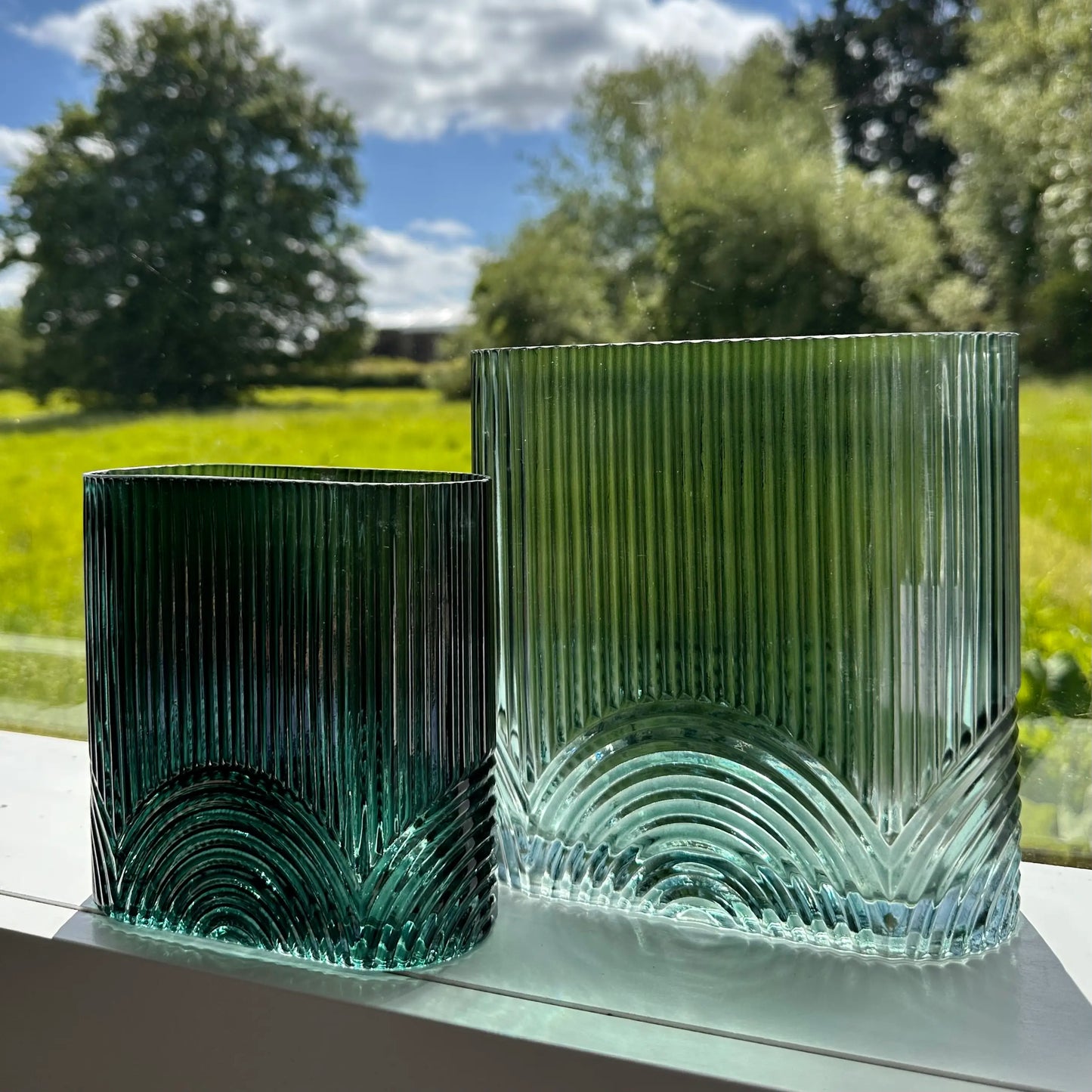 green-glass-ribbed-vases-with-arched-detail-on-windowsill-in-small-and-large-at-albury-house-interiors