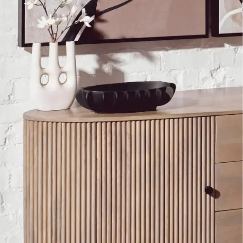 Harlem black oval shaped bowl crafted from aluminium with textured detail, displayed din a monochrome living room. Available to purchase from Albury House Interiors.