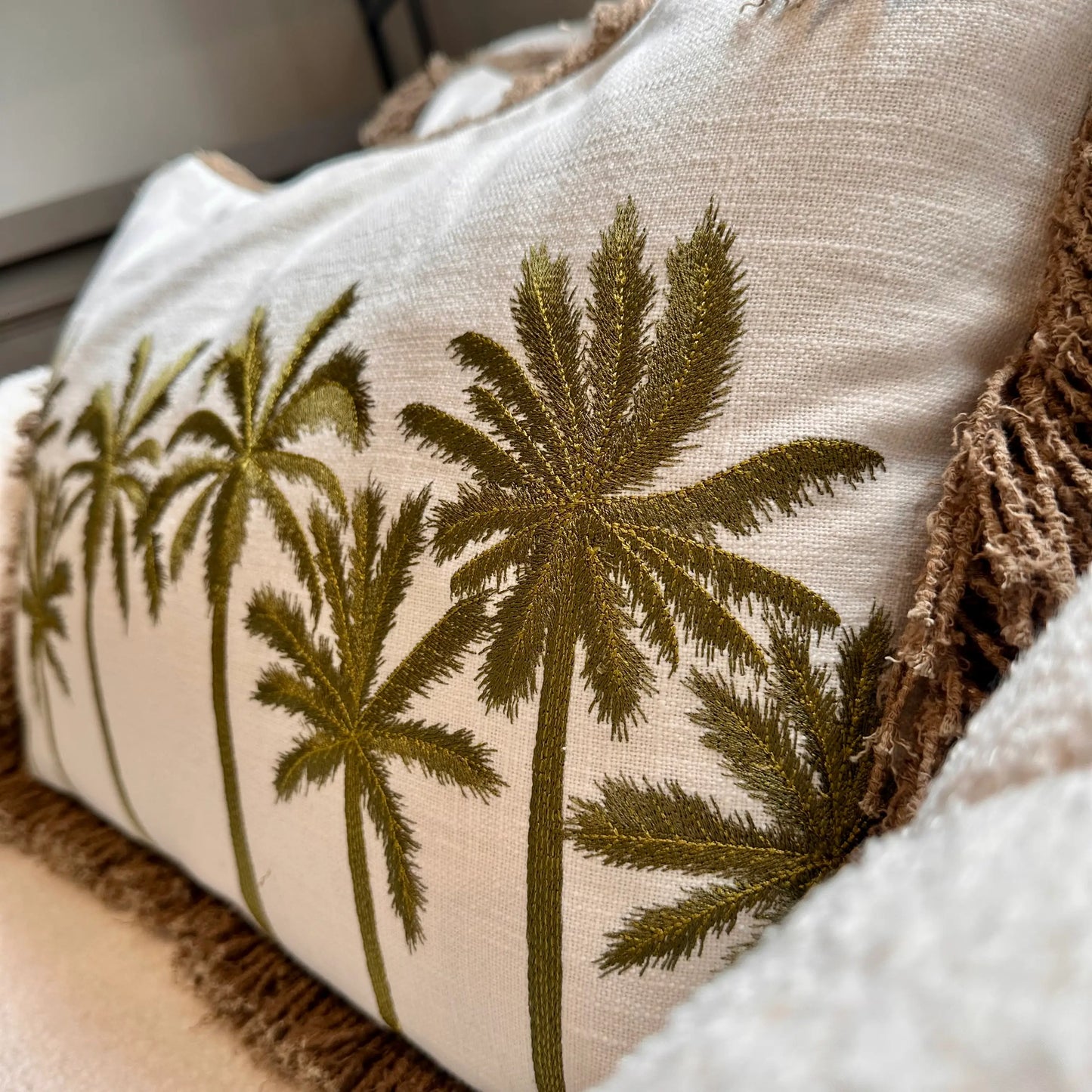 linen-rectangular-cushions-with-embroidered-green-palm-trees-and-brown-fringed-edge-at-albury-house-interiors-shop-essex