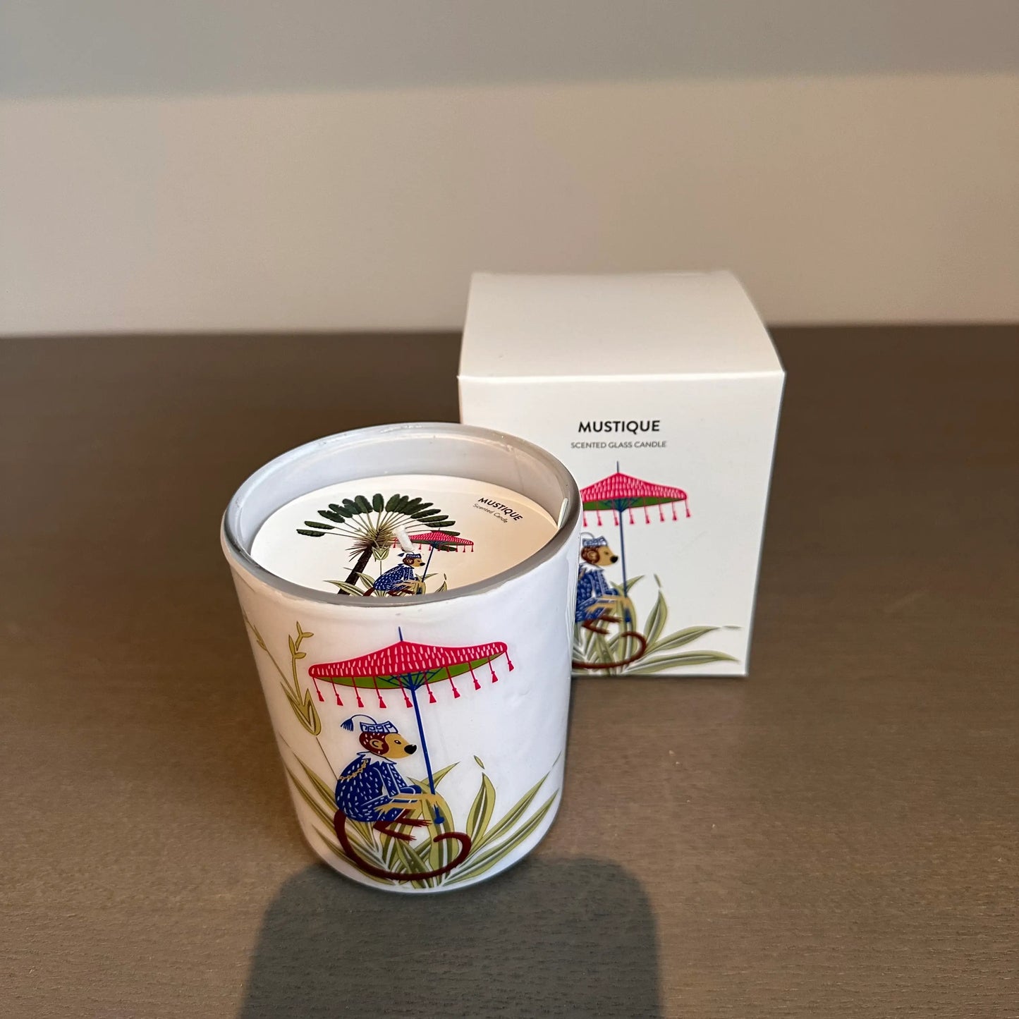 pomegranate-noir-scented-candle-in-glass-jar-with-monkey-umbrella-featured-on-the-front-in-gift-box-at-albury-house-interiors
