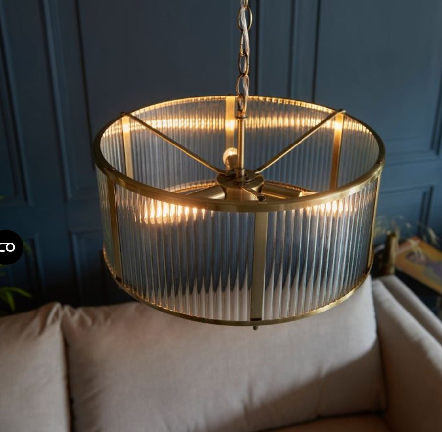 Chandelier with brass finish and clear, ribbed, glass shade hung on a metal chain view from above