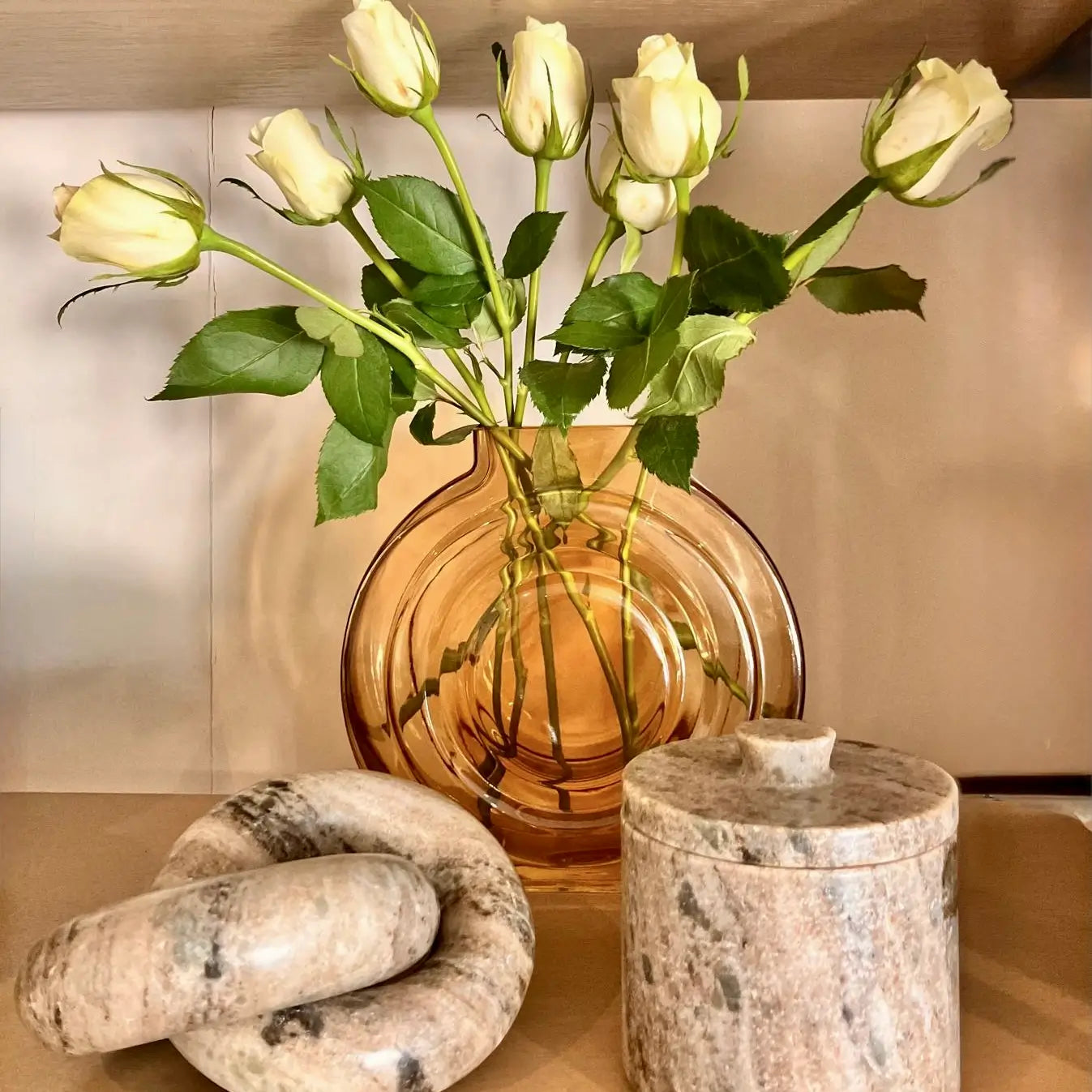 round-amber-glass-vase-with-white-roses-paired-with-taupe-marble-link-chain-sculpture-and-matching-lidded-trinket-pot-at-albury-house-interiors-shop-essex-hertfordshire