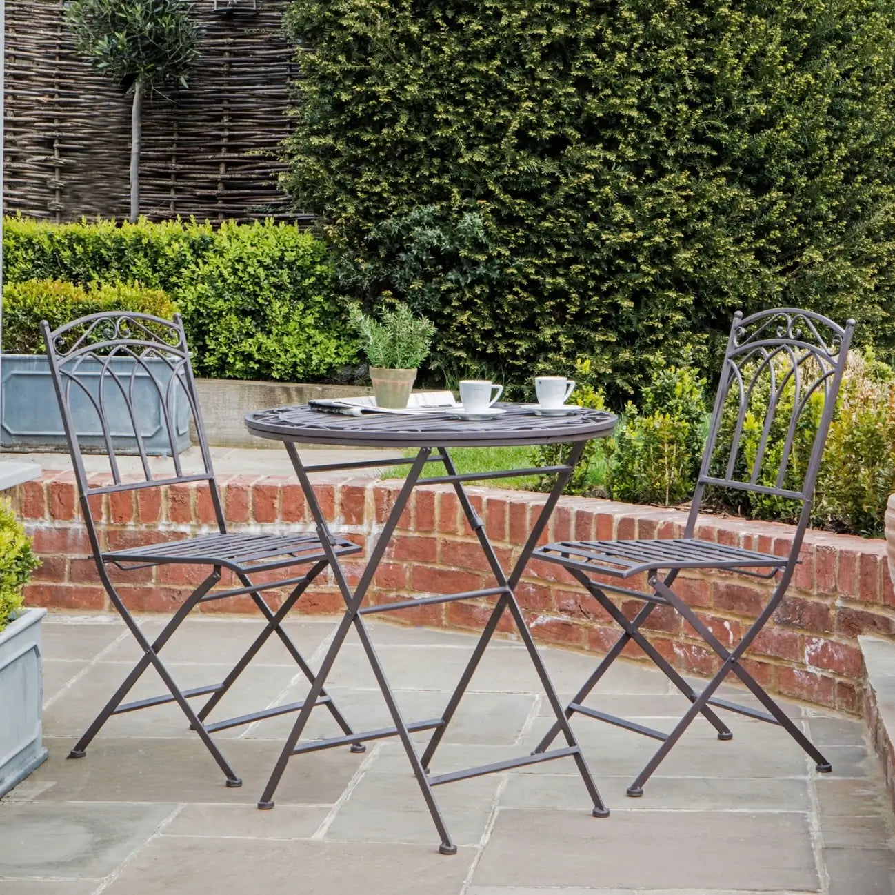 tilbury metal brown outdoor bistro set with two folding chairs and a round table at Albury house interiors