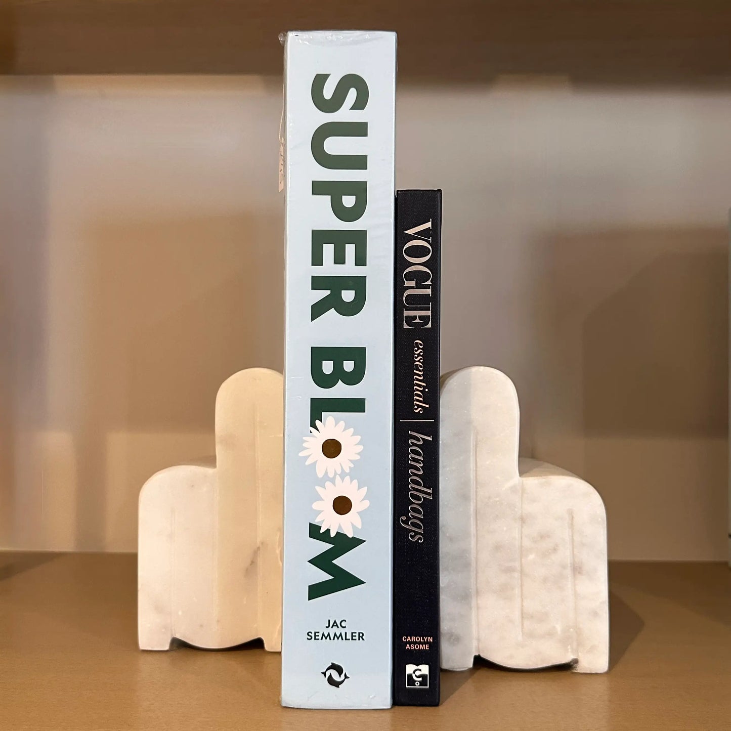 white-veined-natural-marble-arch-bookends-holding-up-baby-blue-super-bloom-and-navy-vogue-essentials-handbags-coffee-table-books-at-albury-house-interiors-essex