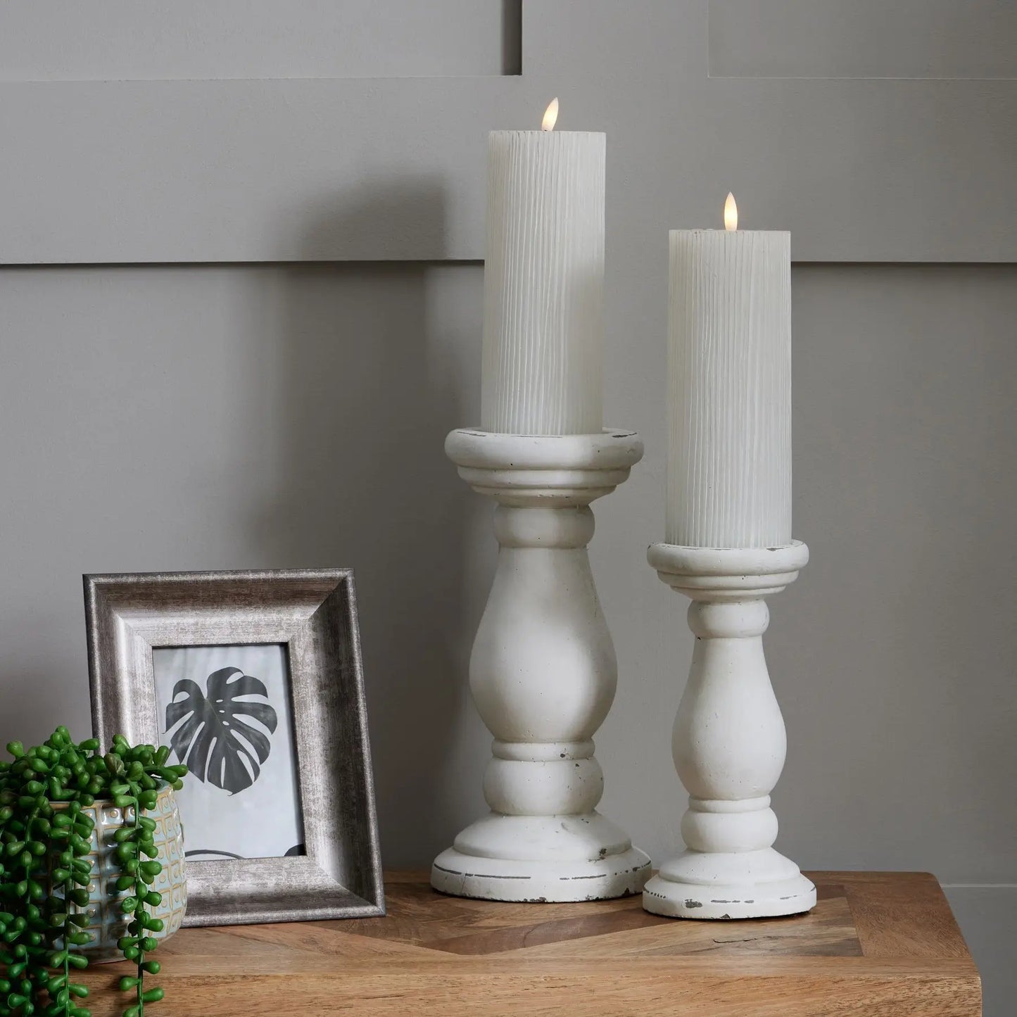 heavy-white-ceramic-pillar-candle-holders-in-sizes-small-and-large-on-sideboard-at-albury-house-interiors-essex