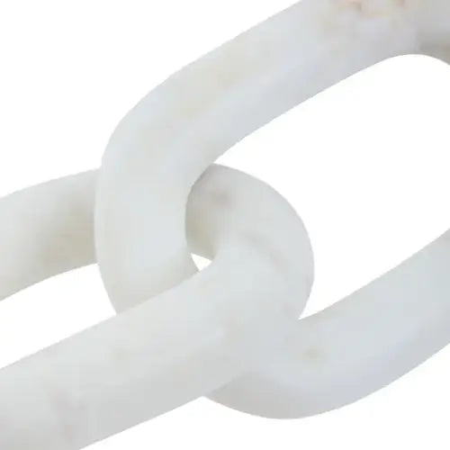 Natural white marble three link chain sculpture, as used by interior designers. Styled on top of a stack of designer coffee table books. Available to purchase from Albury House Interiors, homewares in the UK.