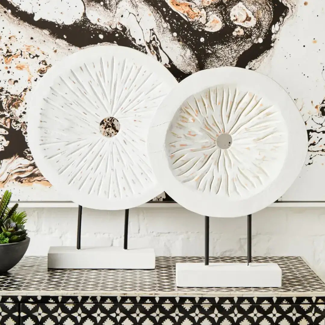 whitewash-wooden-carved-disc-sculptures-small-and-large-on-black-stands-at-albury-house-interiors