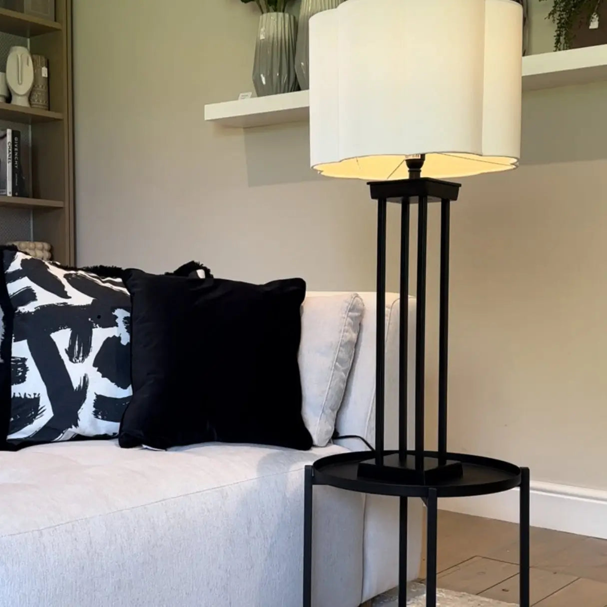 Black metal round side table with matching black legs and removable tray top, styled with black metal column table lamp and white scalloped lampshade. Available to purchase from Albury House Interiors, homewares in the UK. 