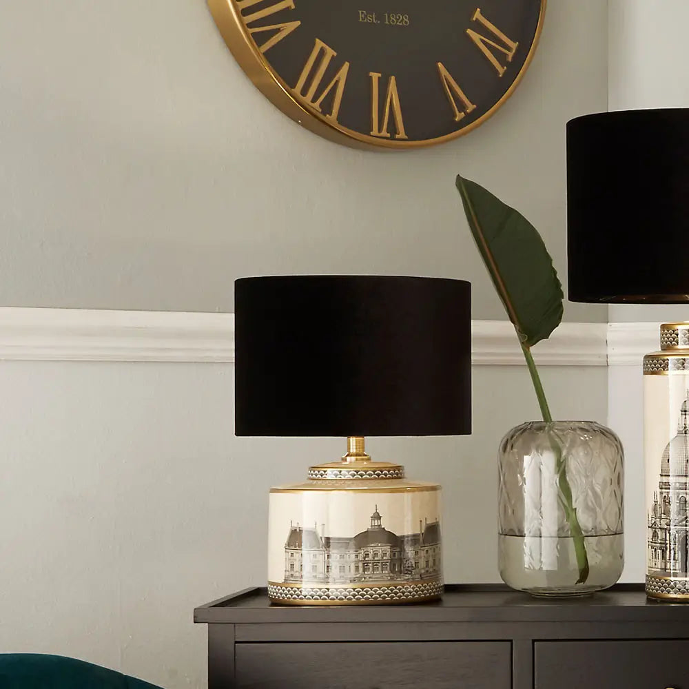 monochrome-black-and-cream-squat-table-lamp-squat-base-with-architectural-buildings-and-gold-detailing-and-black-round-lampshade-at-albury-house-interiors