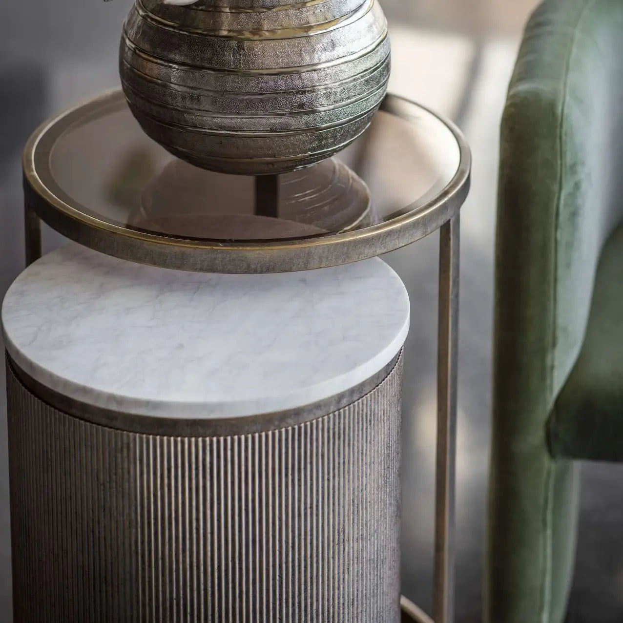 Set of two nesting round side tables, finished in antique bronze with ribbed detailing, and marble and smoked glass table tops. As used by interior designers, available to purchase from Albury House Interiors.