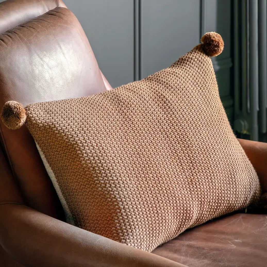 brown-knit-crochet-effect-rectangular-cushion-with-brown-pompoms-on-corners-and-neutral-colour-reverse-side-at-albury-house-interiors-essex