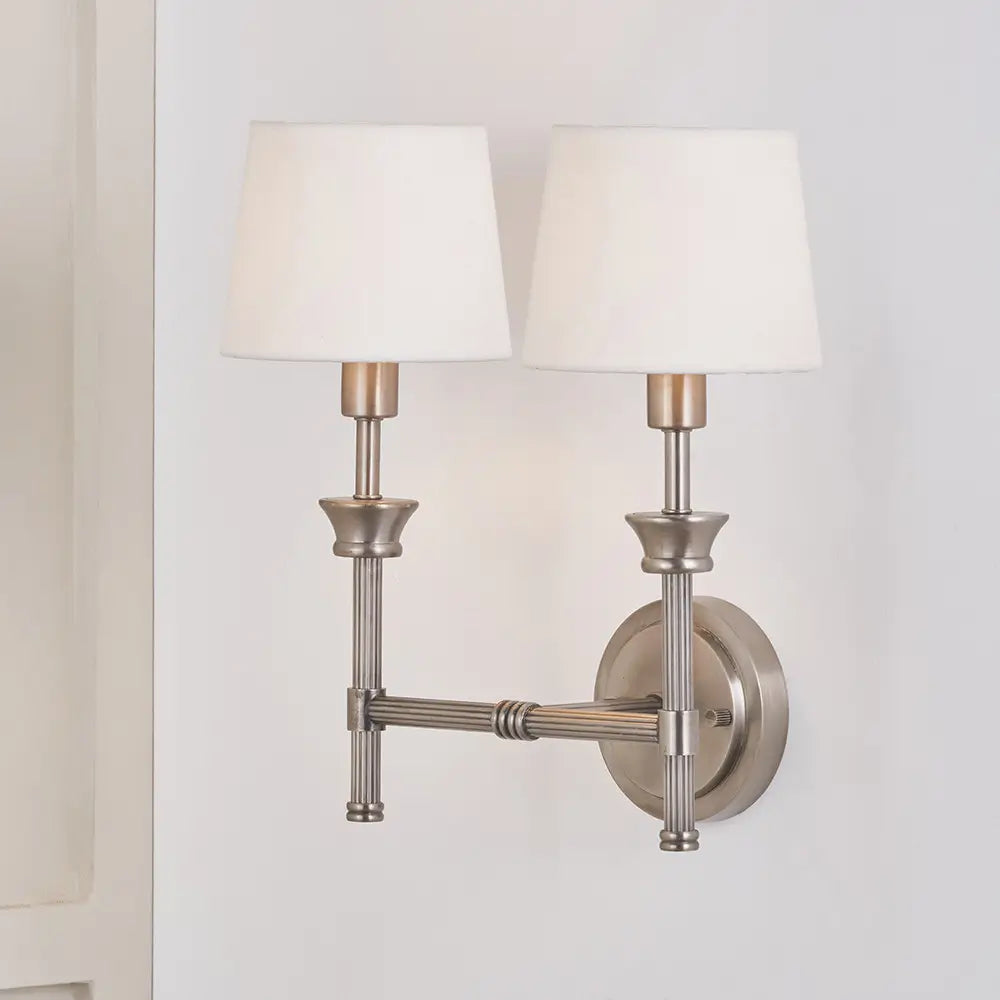 brushed-silver-cast-brass-double-wall-light-with-white-cottom-shades-in-living-room-with-soft-ighting-at-albury-house-interiors