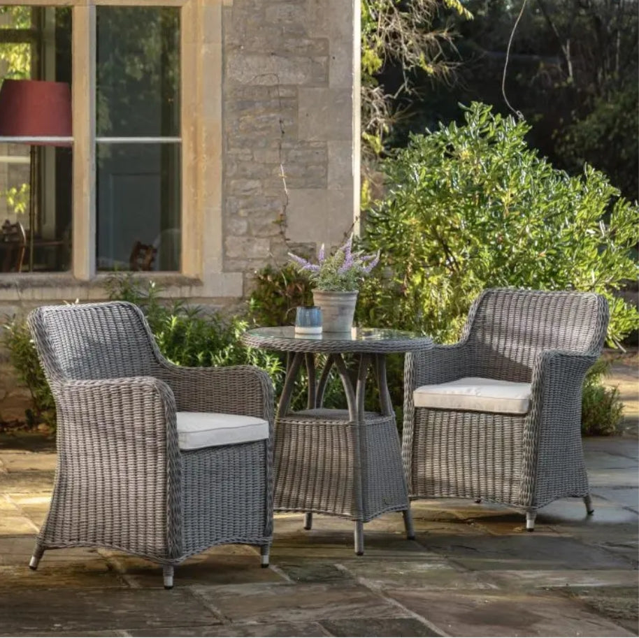 A 3-piece outdoor patio bistro set featuring two grey woven wicker armchairs and a matching round wicker side table on a solid white background.