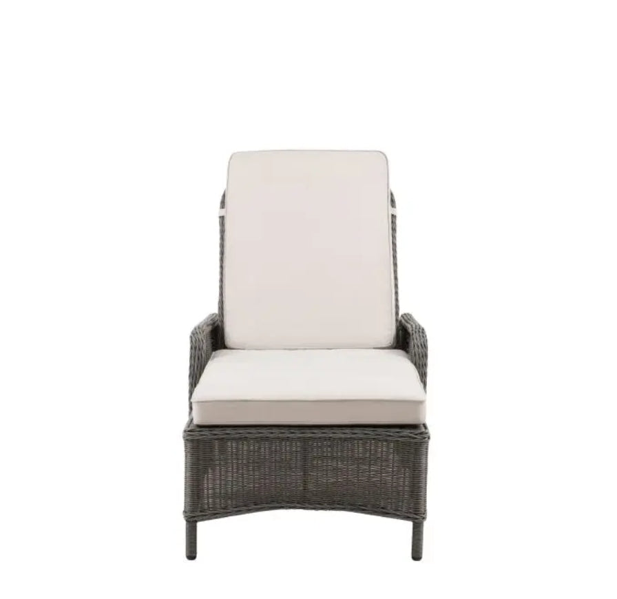 An outdoor reclining wicker Lounger with a tall backrest, featuring light beige cushions on the seat and back, set against a plain white background.