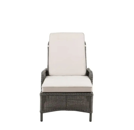 An outdoor reclining wicker Lounger with a tall backrest, featuring light beige cushions on the seat and back, set against a plain white background.