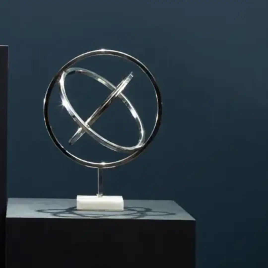 chrome-siver-spiral-round-sculpture-on-marble-base-at-albury-house-interiors