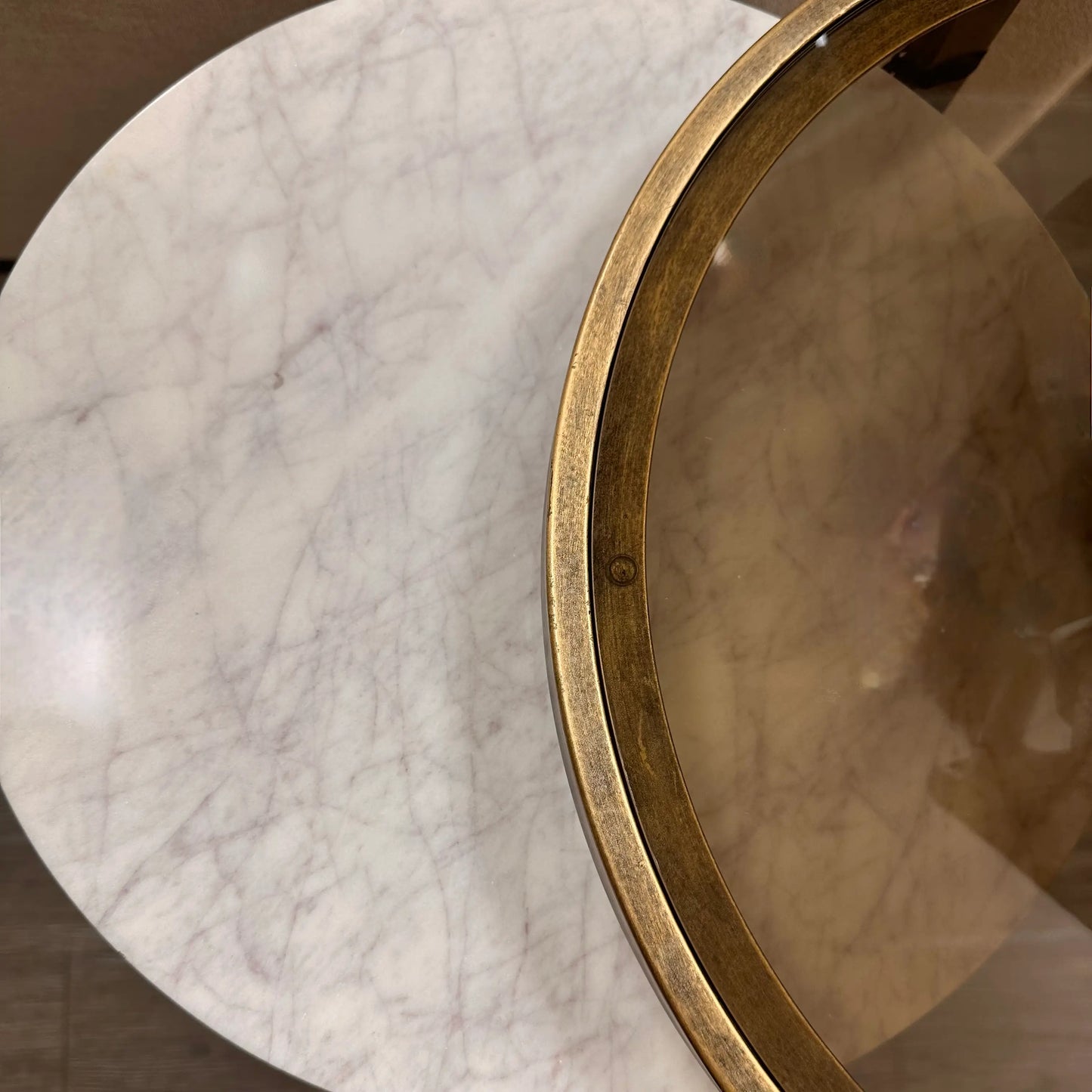 Set of two nesting round side tables, finished in antique bronze with ribbed detailing, and marble and smoked glass table tops. As used by interior designers, available to purchase from Albury House Interiors.