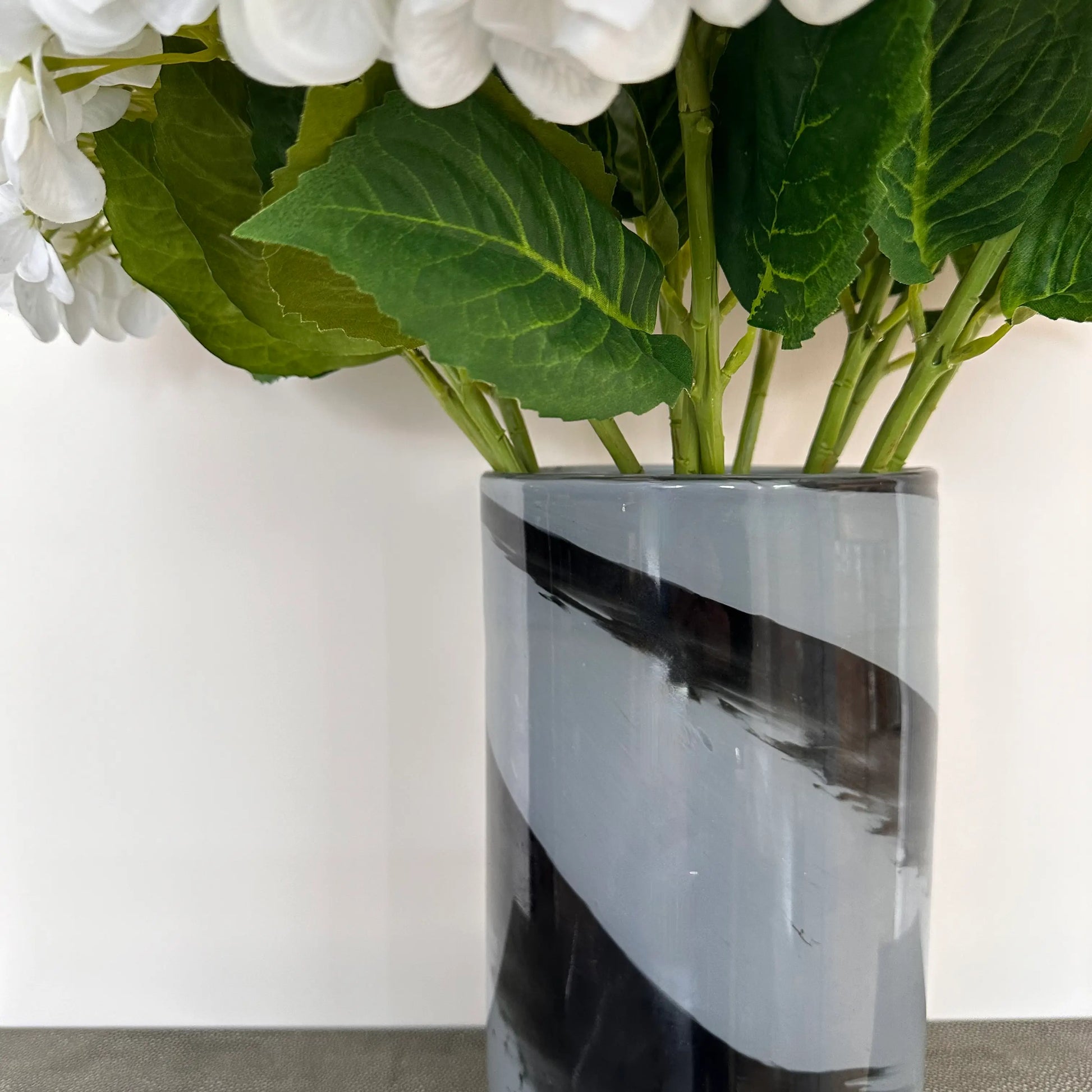 Black and grey glass swirl vase size small, perfect for faux flowers, real plants and fresh flowers. Available to purchase at Albury House Interiors, homewares and home decor shop in Essex. 
