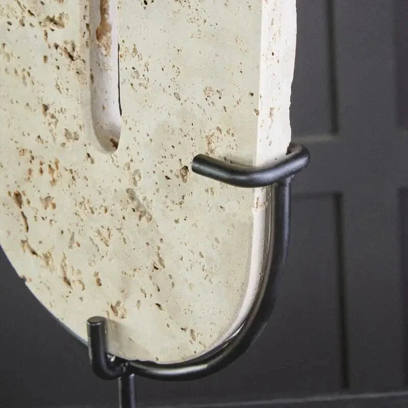 Natural travertine stone oval shaped disc displayed on matte black stand, used by interior designers. Available to purchase from Albury House Interiors. 