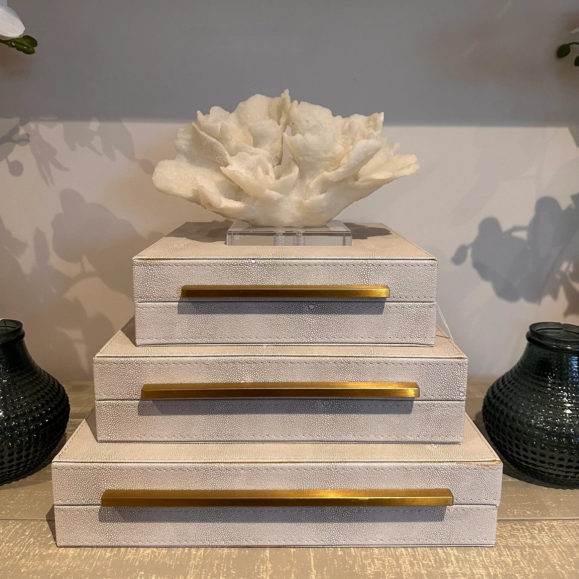 cream-faux-coral-sculpture-on-clear-acrylic-base-on-top-of-cream-faux-shagreen-boxes-at-albury-house-interiors