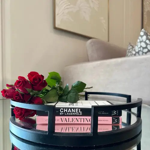 Chanel and Valentino hardback designer coffee table books with red roses, displayed on Cruz black round tray with mirrored base. Available to purchase from Albury House Interiors. 