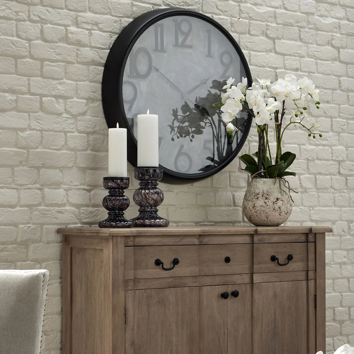 White faux realistic orchid flower in antique stone rustic pot, displayed on a solid oak sideboard - available to purchase from Albury House Interiors.