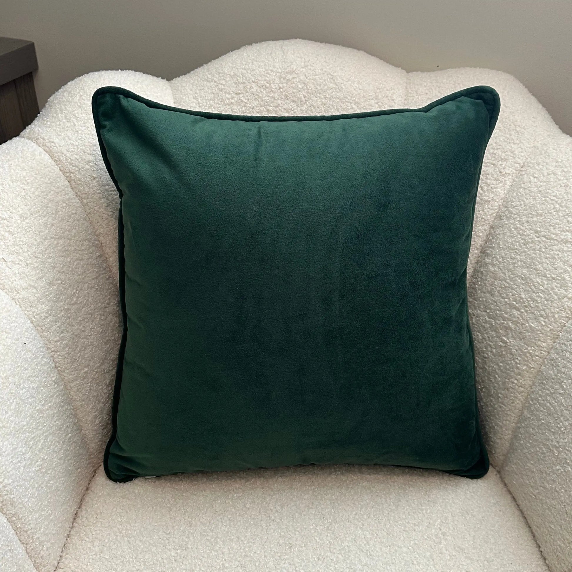 forest-green-velvet-piped-cushion-on-white-boucle-chair-at-albury-house-interiors