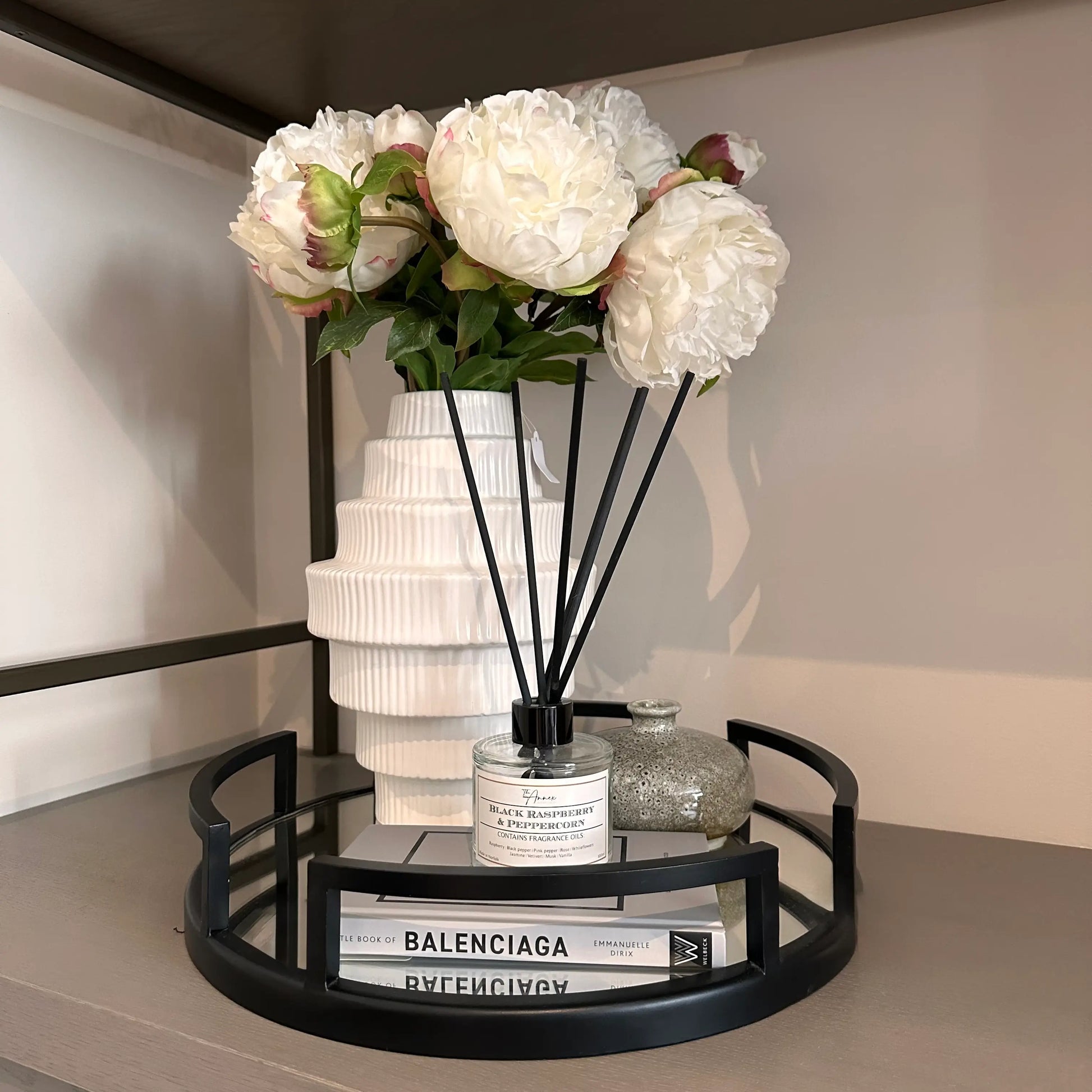 black-cruz-mirrored-tray-with-white-tiered-ribbed-vase-balenciaga-book-and-grey-ceramic-bud-vase-at-albury-house-interiors