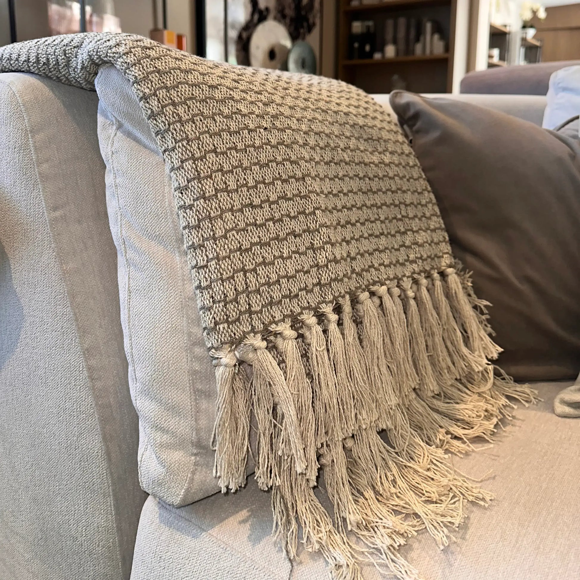 Basket weave throw in grey and taupe colours with fringed edges at both ends, crafted from recycled materials. Available to purchase from Albury House Interiors.