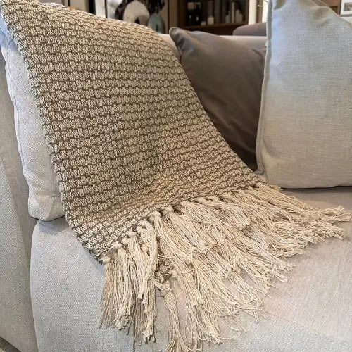 Basket weave throw in grey and taupe colours with fringed edges at both ends, crafted from recycled materials. Available to purchase from Albury House Interiors.