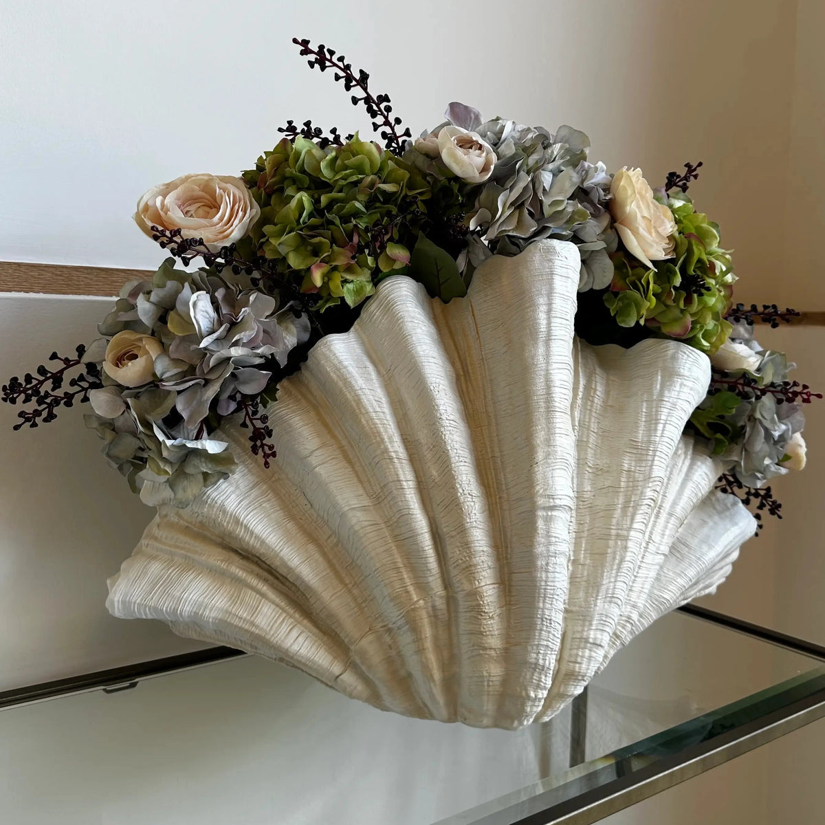 Extra large resin clam shell in off-white, with green and silver faux hydrangeas and pink peonies. All items available to purchase at Albury House Interiors, homewares and accessories in Matching Tye, Essex. 