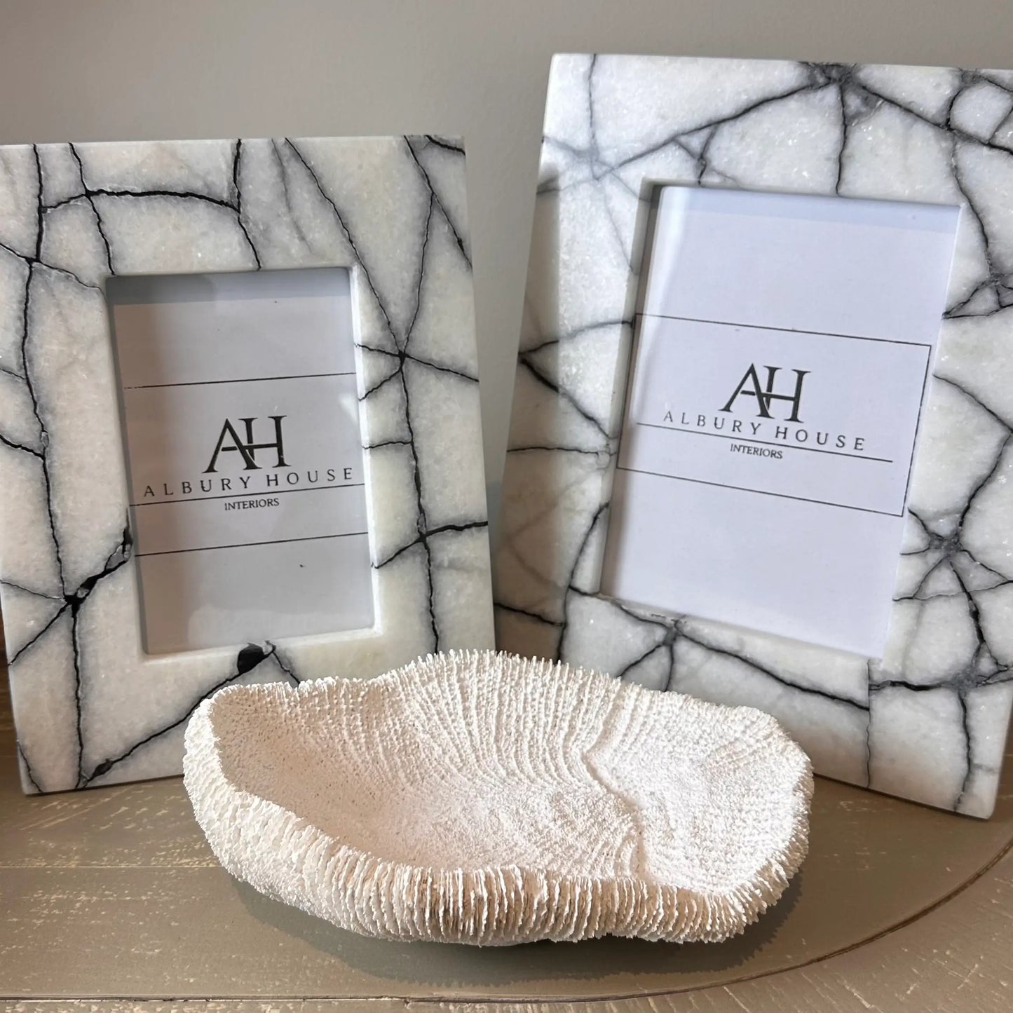 black-and-white-natural-marble-photoframes-with-white-faux-fungia-coral-bowl-ornament-at-albury-house-interiors-essex