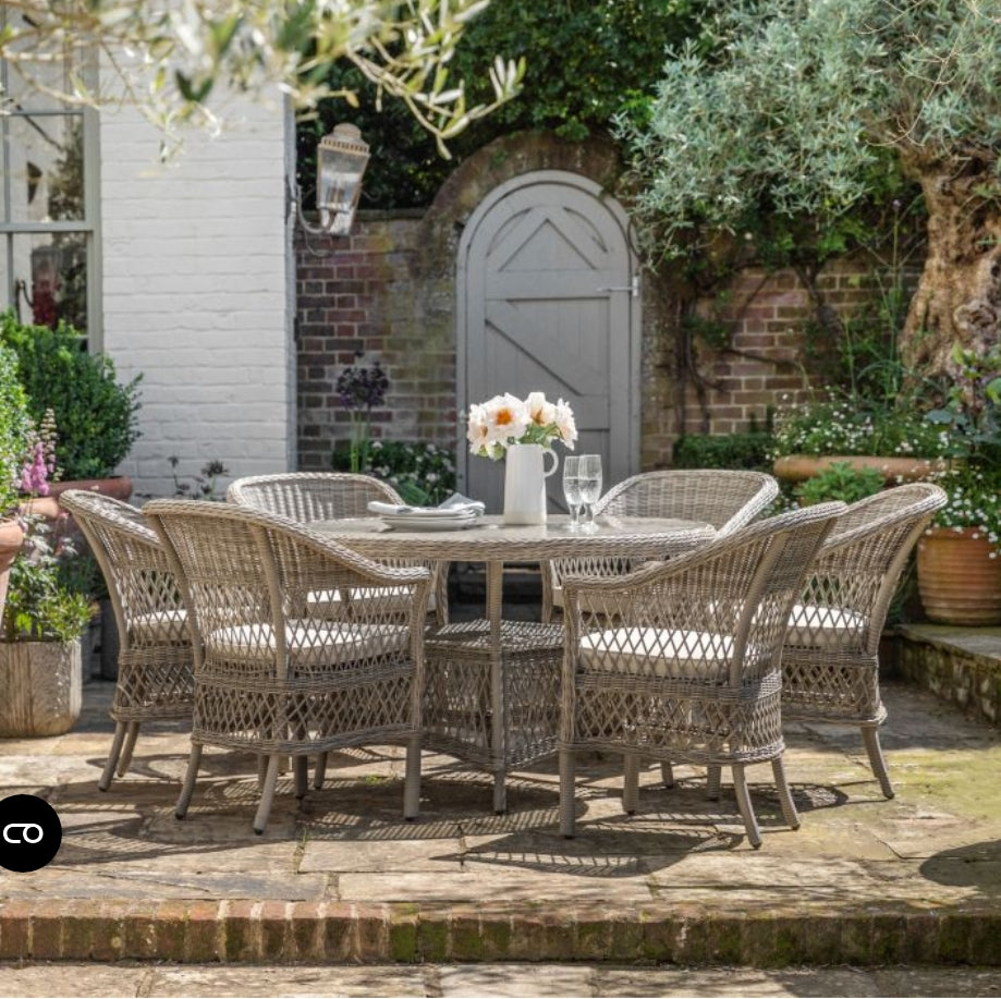 Moreton stone grey colour rattan outdoor furniture, 6 chairs and a glass topped round dining table with showerproof seat and back cushions, available at Albury House Interiors