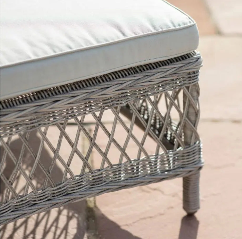 Moreton reclining, all weather, stone coloured rattan lounger with matching weather proof cushions. Pretty open weave rattan, positioned around a pool, available at Albury House Interiors.