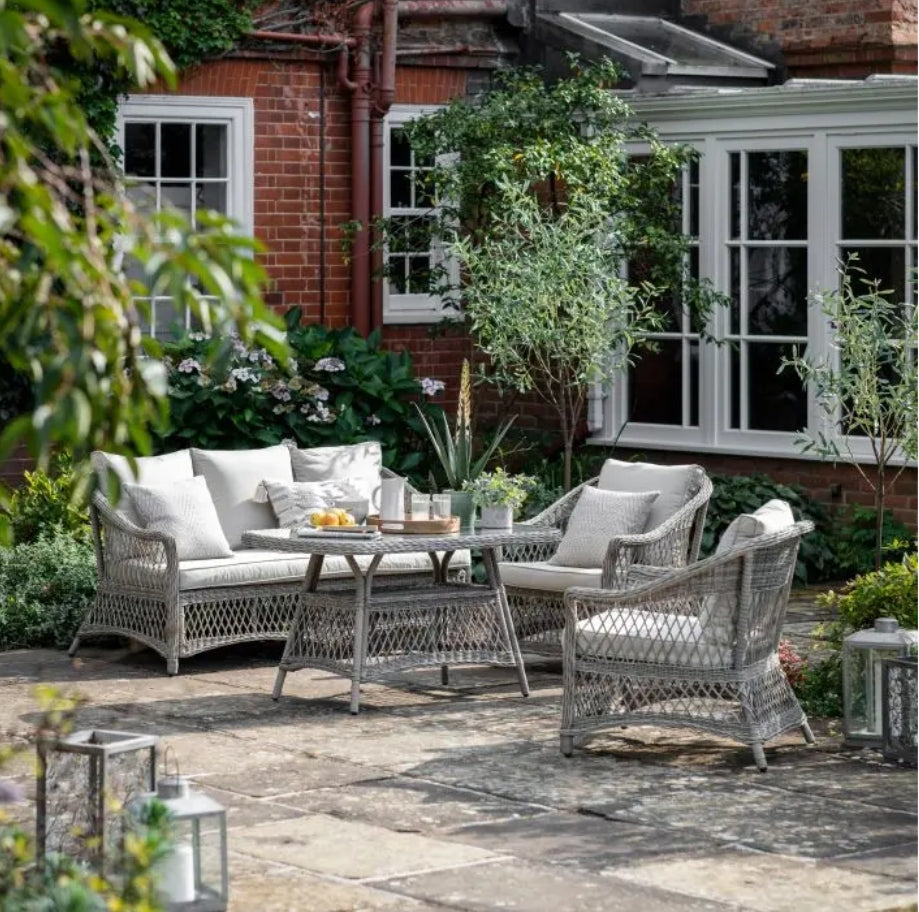 Moreton stone grey colour rattan outdoor furniture, 3-seater sofa, two armchairs and a dining table with showerproof seat and back cushions, available at Albury House Interiors