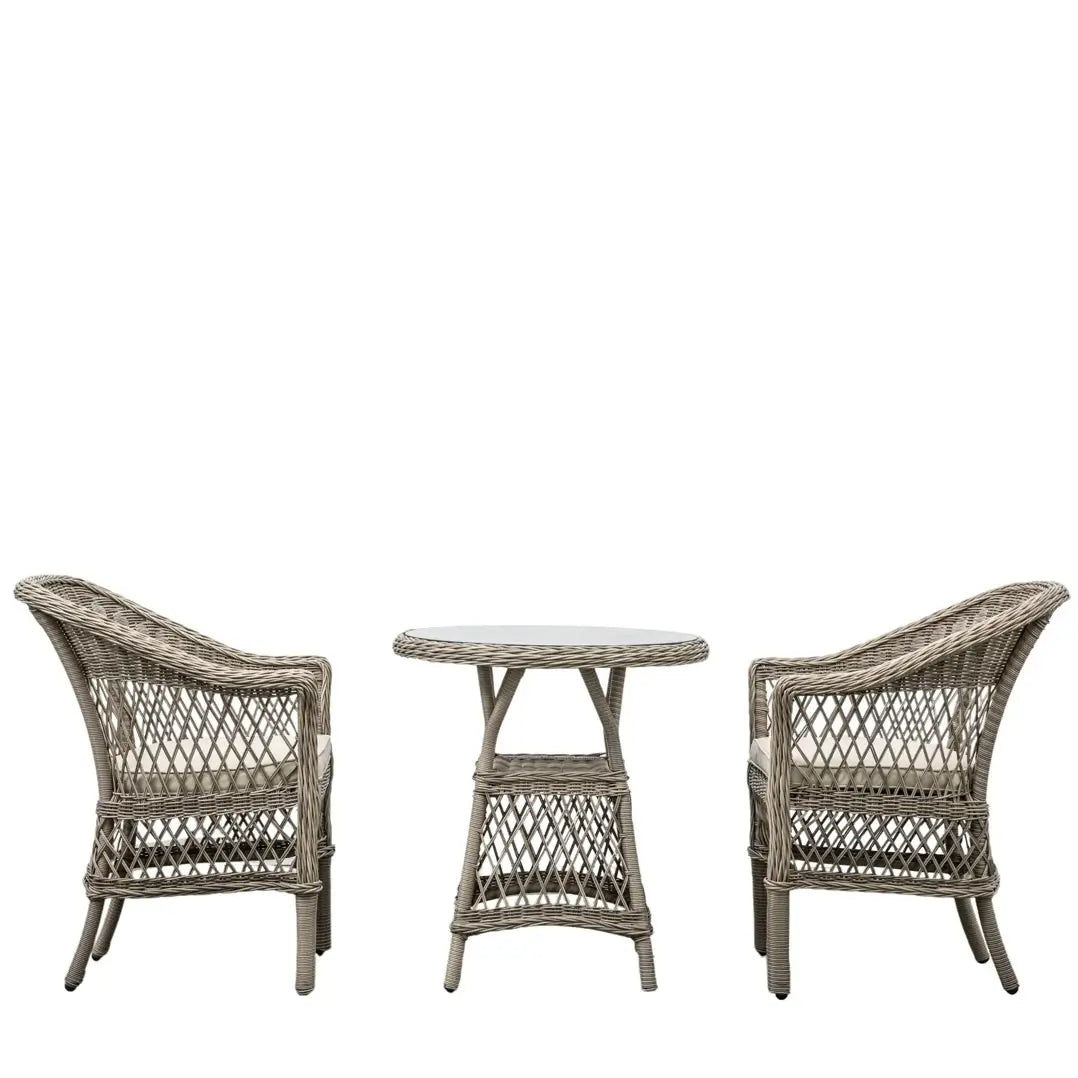 Moreton rattan woven outdoor bistro set with two armchair style seats with natural coloured weatherproof cushions and round rattan glass top table. Available to purchase at Albury House Interiors.