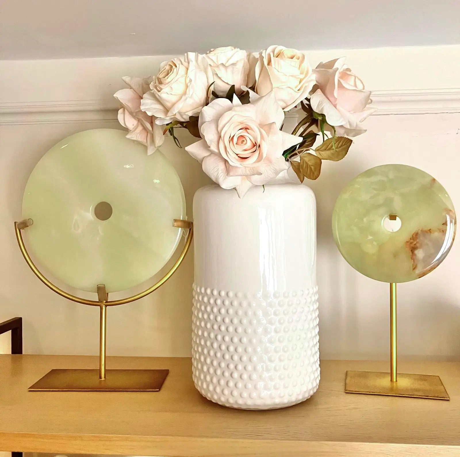 pair-of-natural-green-jade-stone-round-discs-on-distressed-gold-stands-with-ceramic-white-dimple-vase-and-real-feel-roses-at-albury-house-interiors-essex