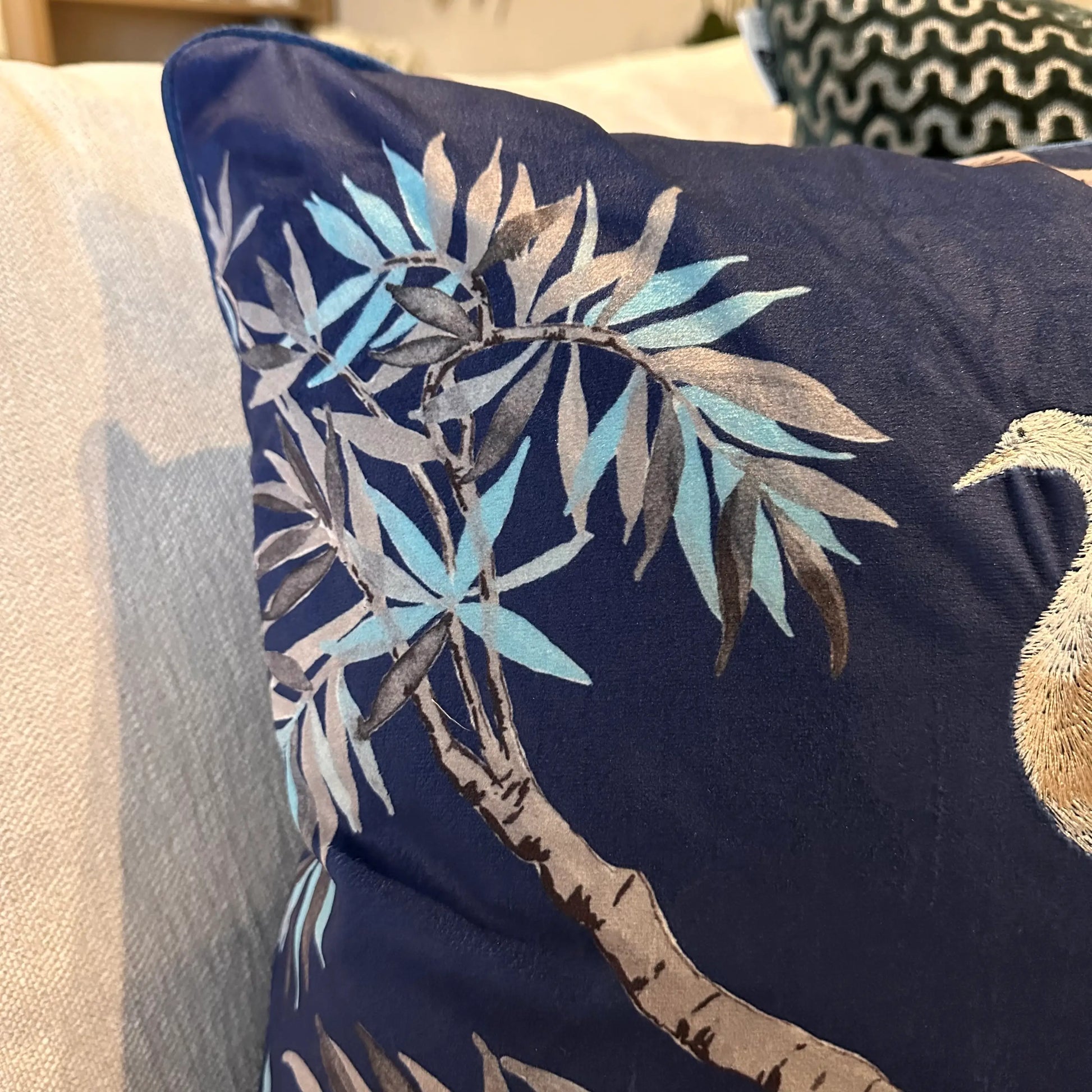 Navy blue square velvet cushion, with embroidered crane birds and delicate tree and leaf detailing, at Albury House Interiors