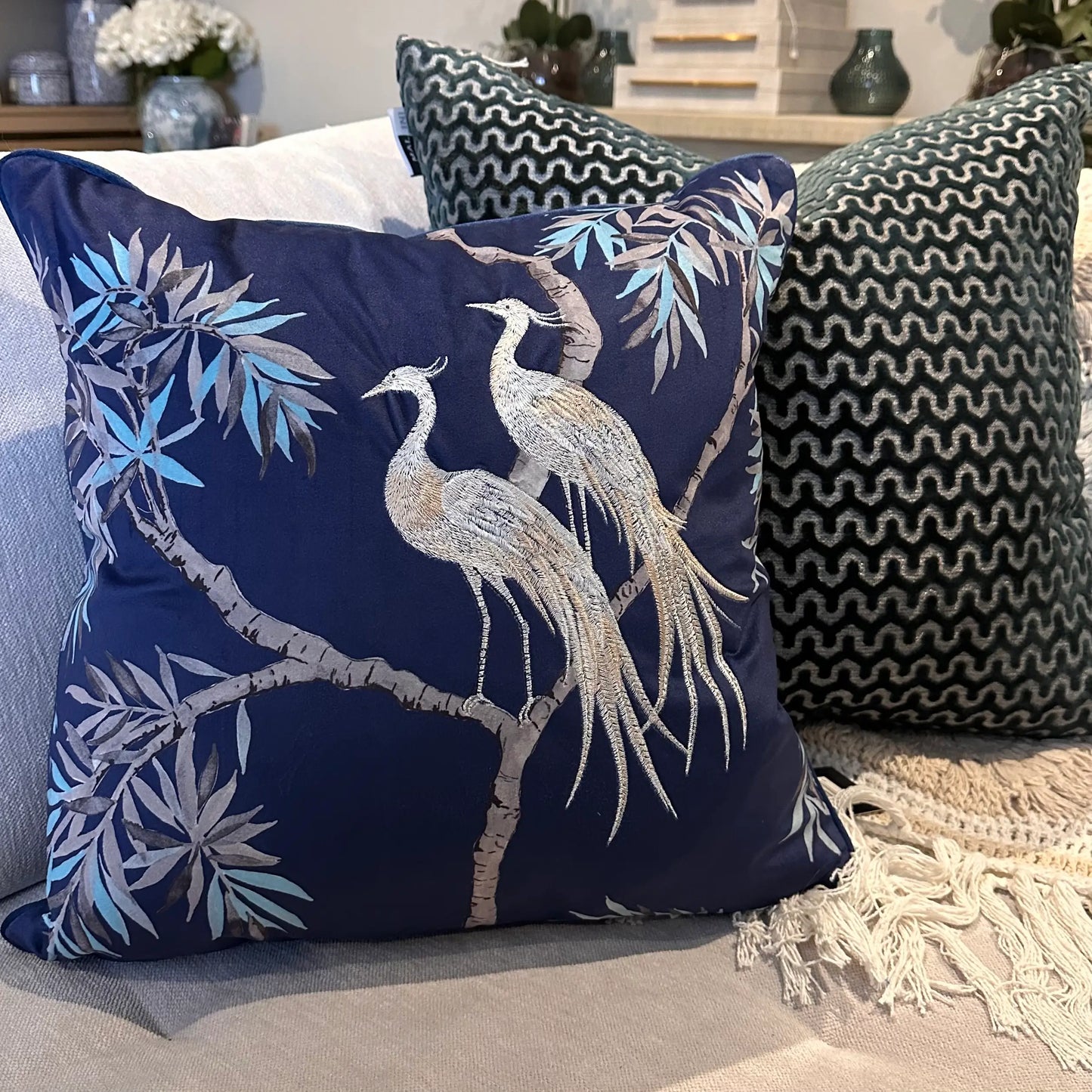 Navy blue square velvet cushion, with embroidered crane birds and delicate tree and leaf detailing, at Albury House Interiors