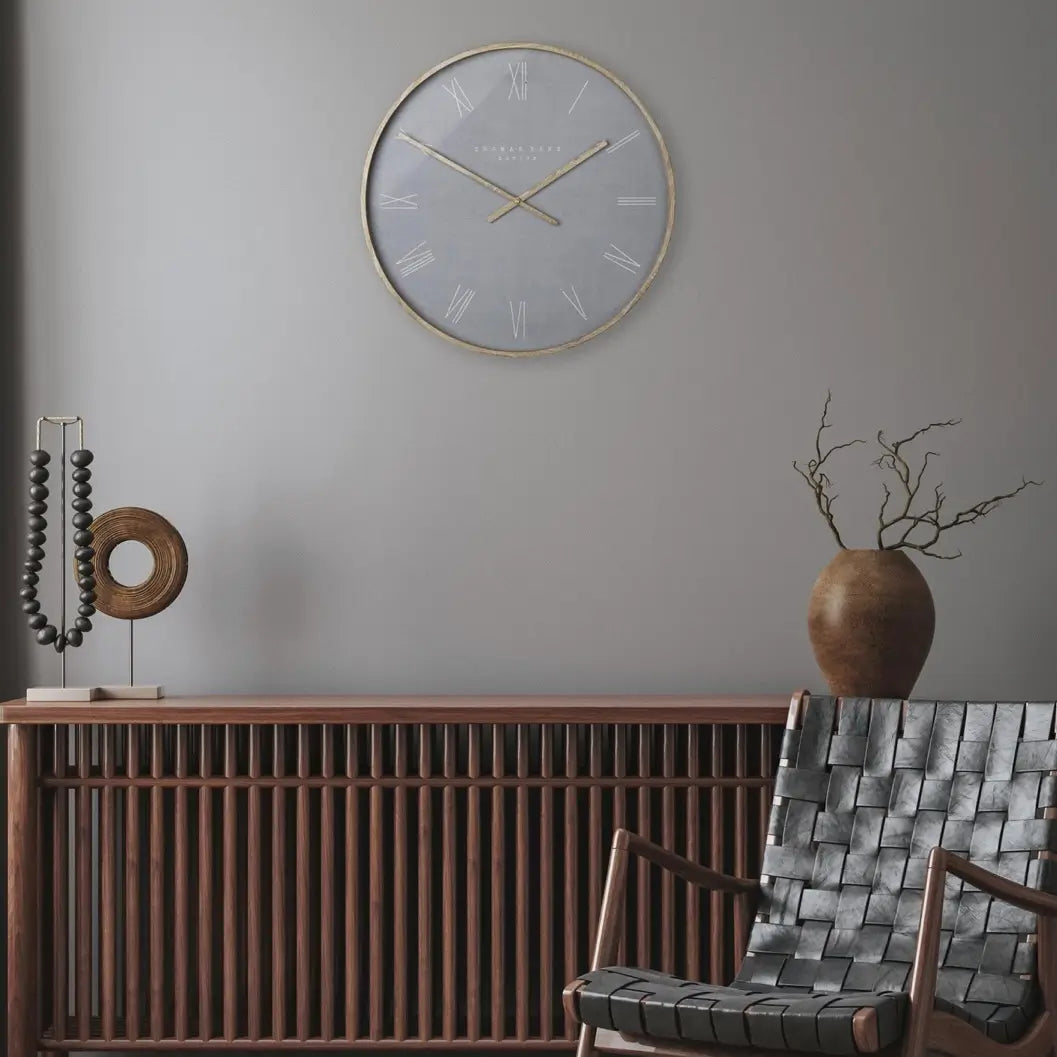 Norway round wall clock in cement grey with wooden effect hands and front rim and roman numeral numbers. Available to purchase at Albury House Interiors.