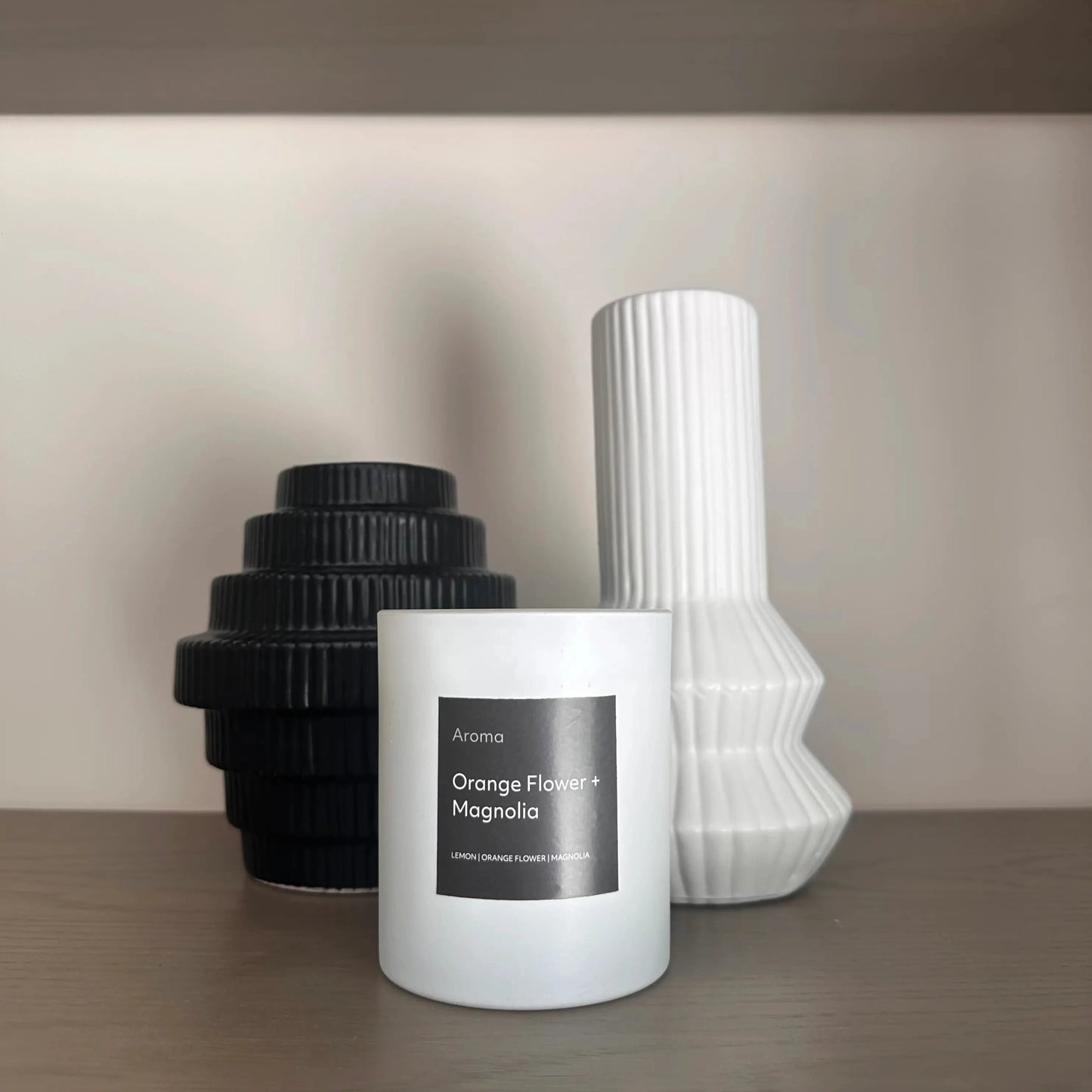 orange-flower-and-magnolia-scentyed-black-and-white-candle-with-harpa-black-stepped-and-white-vases-on-shelving-unit-at-albury-house-interiors