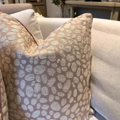 Square feather filled cushion with pebble textured pattern in rose pink and grey tones, and matching piped edges. Available to purchase at Albury House Interiors.
