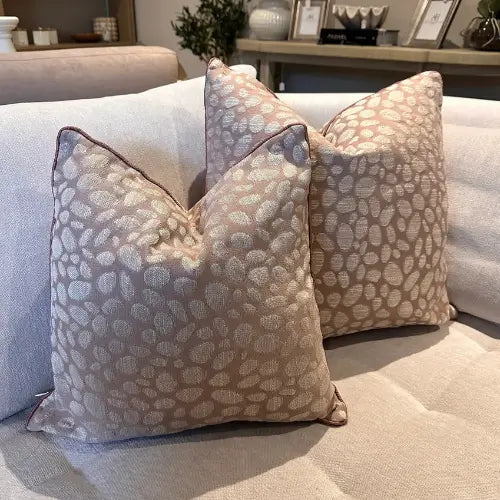 Square feather filled cushion with pebble textured pattern in rose pink and grey tones, and matching piped edges. Available to purchase at Albury House Interiors.